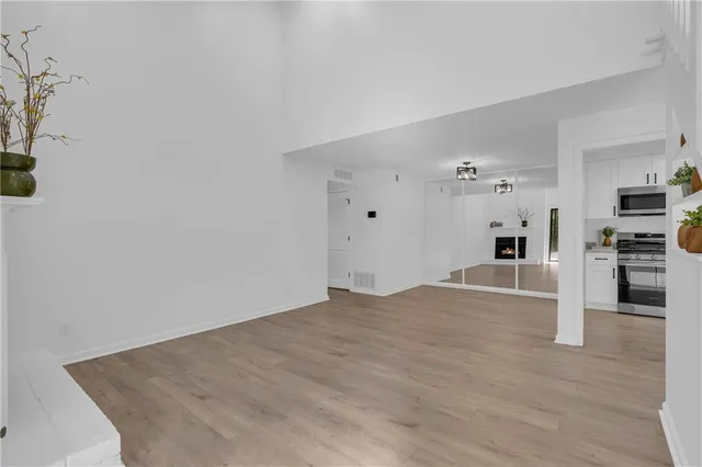 a view of a kitchen with wooden floor and a refrigerator