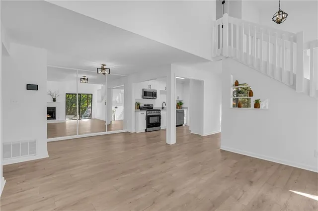 a view of empty room with wooden floor and windows