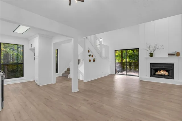 a view of a livingroom with wooden floor and a fireplace