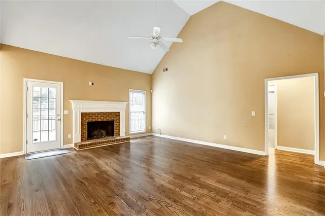 an empty room with wooden floor and fireplace