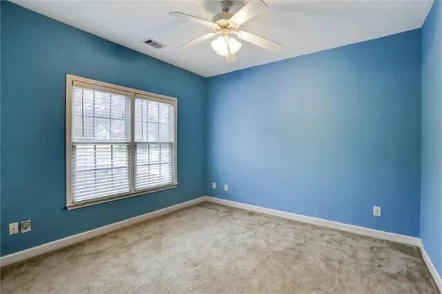 an empty room with a window and a fan