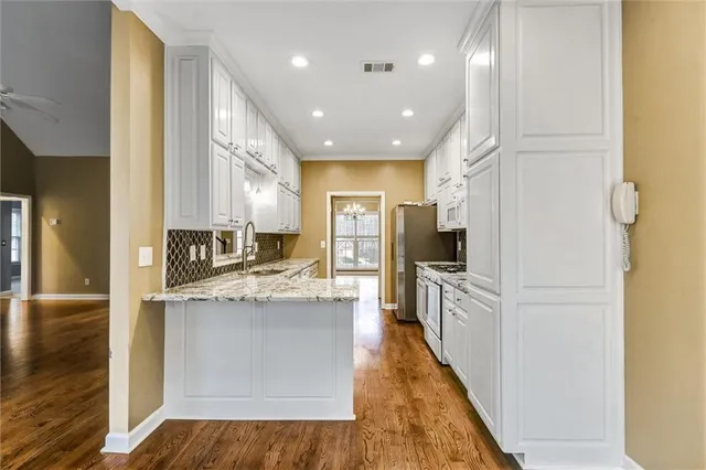 a large kitchen with stainless steel appliances granite countertop a large counter top and a stove