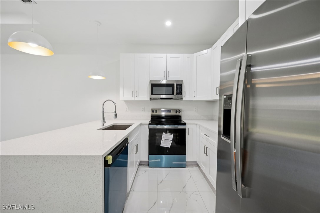 4701-4703 28th Street Southwest Lehigh Acres, FL 33973 - Photo 11 of 37 a kitchen with a sink stainless steel appliances and cabinets
