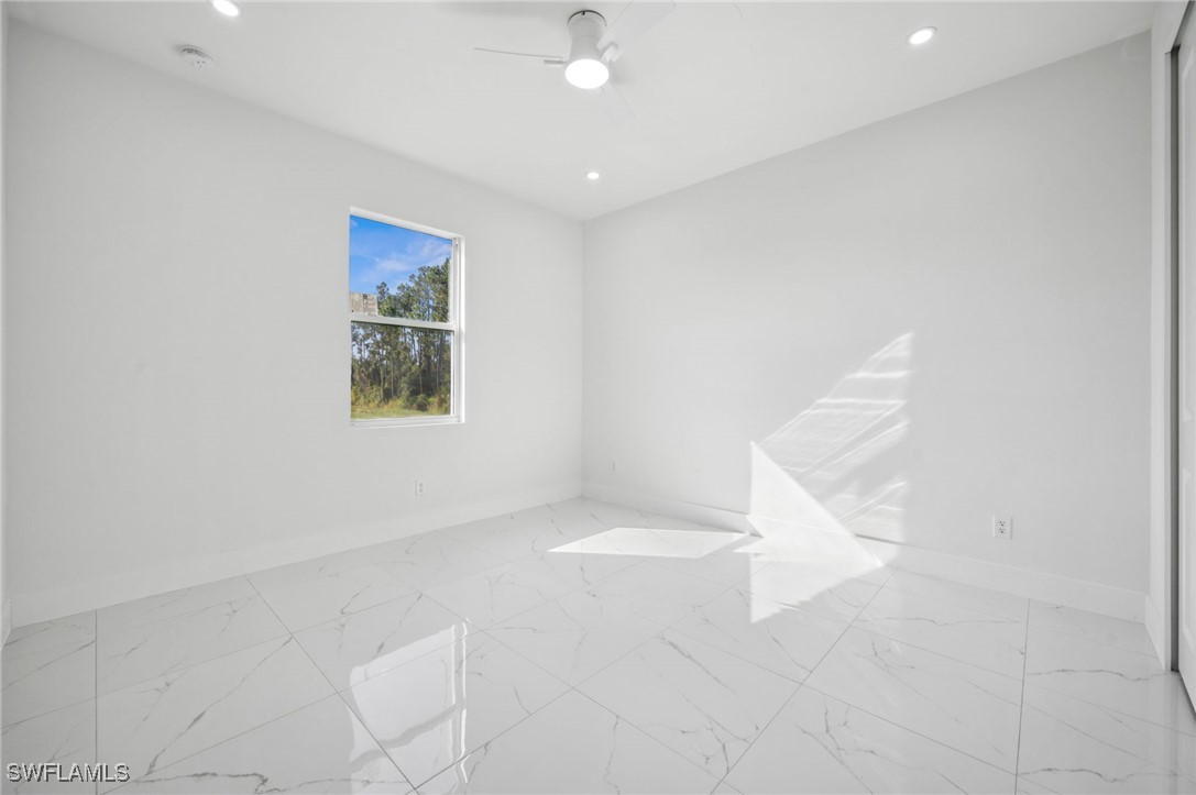 4701-4703 28th Street Southwest Lehigh Acres, FL 33973 - Photo 13 of 37 an empty room with a ceiling fan and windows