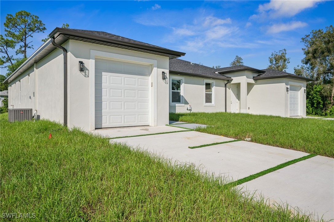 4701-4703 28th Street Southwest Lehigh Acres, FL 33973 - Photo 2 of 37 a front view of a house with a yard and garage