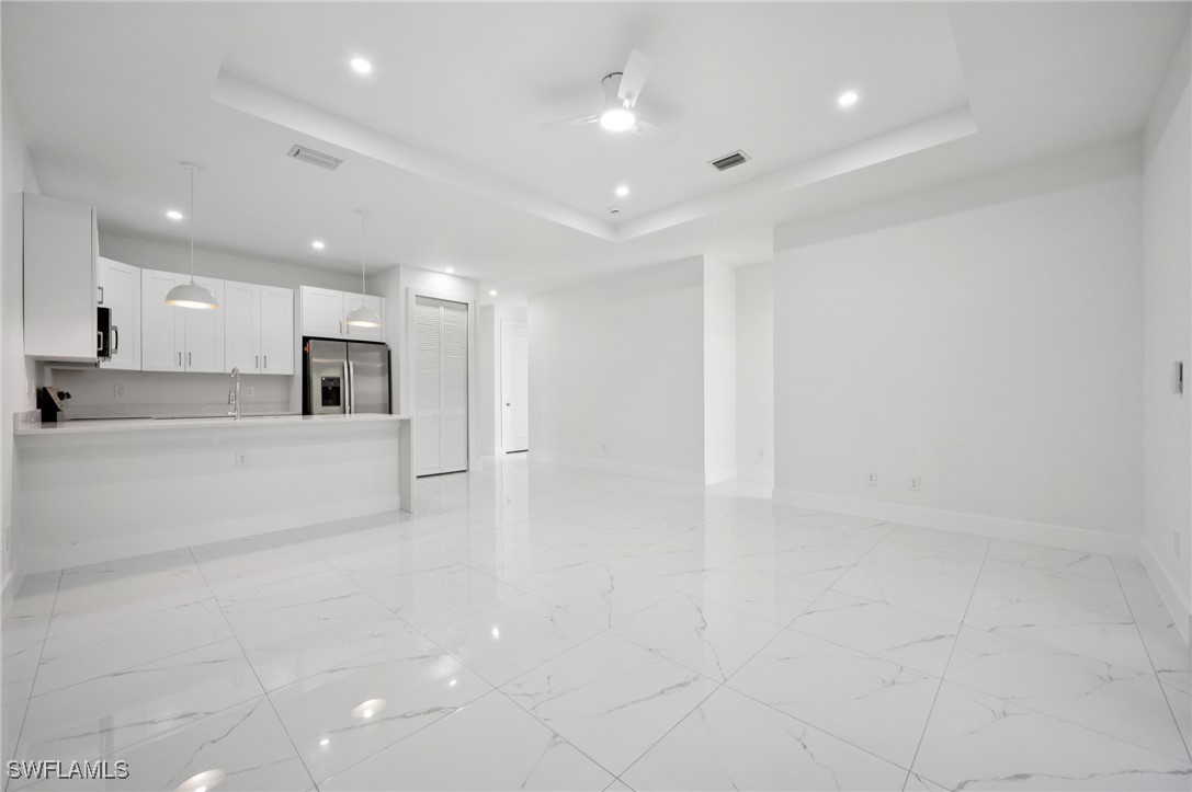 4701-4703 28th Street Southwest Lehigh Acres, FL 33973 - Photo 5 of 37 a view of kitchen with kitchen island white cabinets and stainless steel appliances