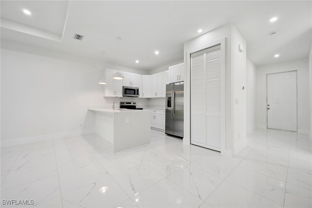 4701-4703 28th Street Southwest Lehigh Acres, FL 33973 - Photo 9 of 37 a kitchen with stainless steel appliances a refrigerator sink and microwave