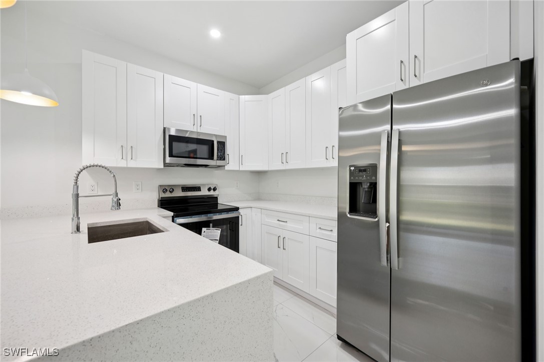 4701-4703 28th Street Southwest Lehigh Acres, FL 33973 - Photo 10 of 37 a kitchen with a refrigerator stove and microwave