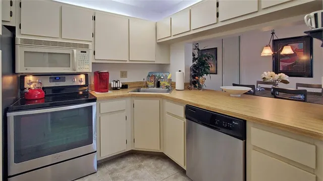 a kitchen with refrigerator a microwave a stove and cabinets