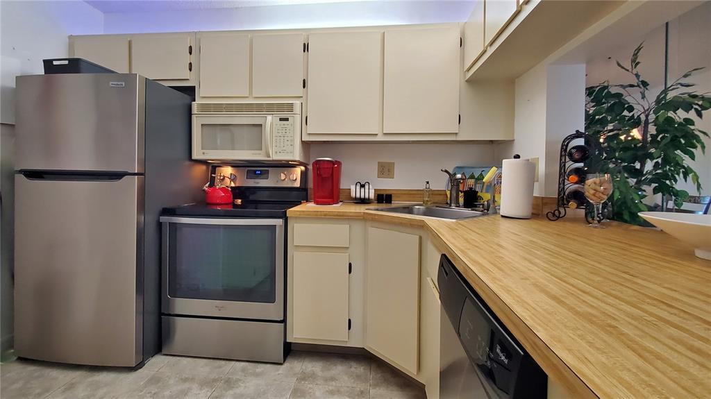 928 South Pine Ridge Circle Sanford, FL 32773 - Photo 10 of 22 a kitchen with refrigerator a microwave a stove and cabinets