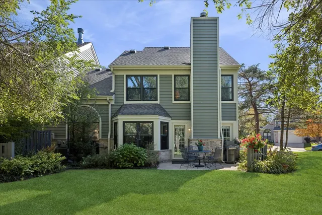 a front view of a house with a yard and green space