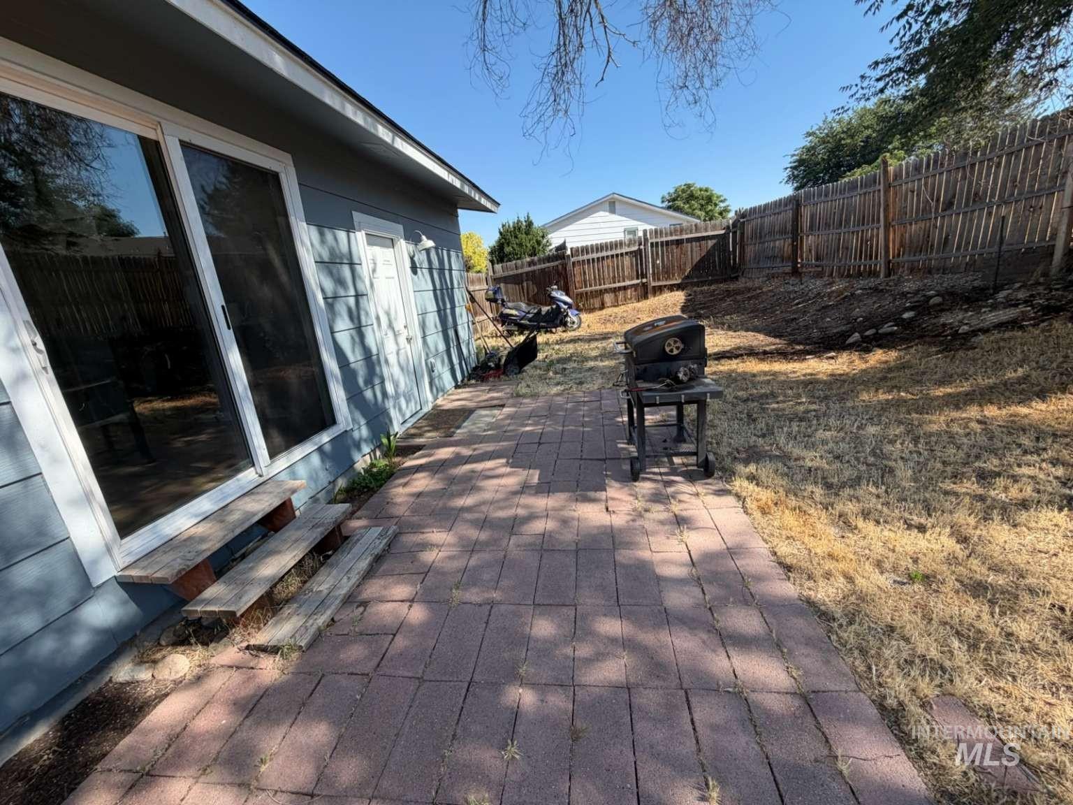 9951 West Fox Ridge Drive Boise, ID 83709 - Photo 5 of 13 Paver patio with direct access to interior spaces via sliding glass doors and a side entry door