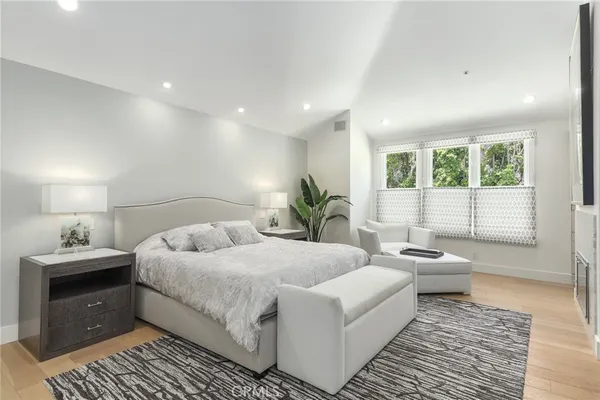 a bedroom with a large bed and wooden floor