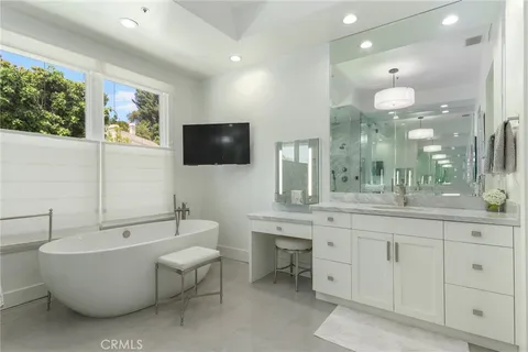 a spacious bathroom with a large mirror vanity and bathtub