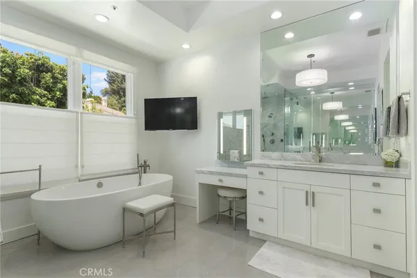 a spacious bathroom with a large mirror vanity and bathtub