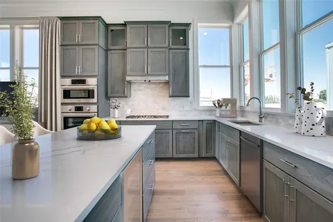 a kitchen with a sink a counter space cabinets and appliances
