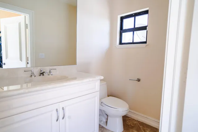 a bathroom with a sink a toilet and a window