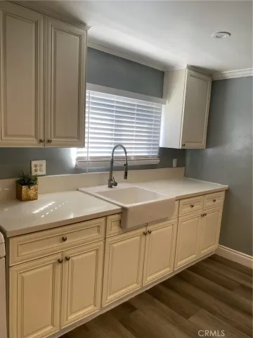 a kitchen with white cabinets and sink