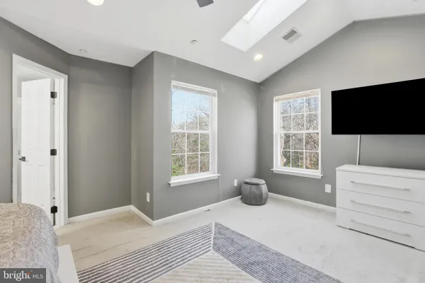a bedroom with a large bed and a painting on the wall