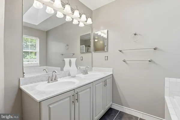 a white bath tub sitting in a bathroom next to a window