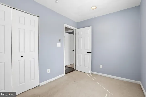 a view of a room with a chair and frames on wall