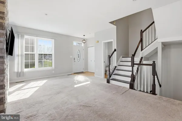 a view of empty room with stairs and windows