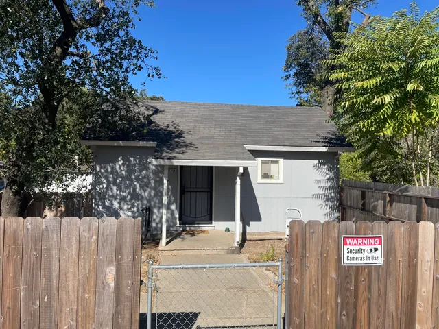 a front view of a house with a tree
