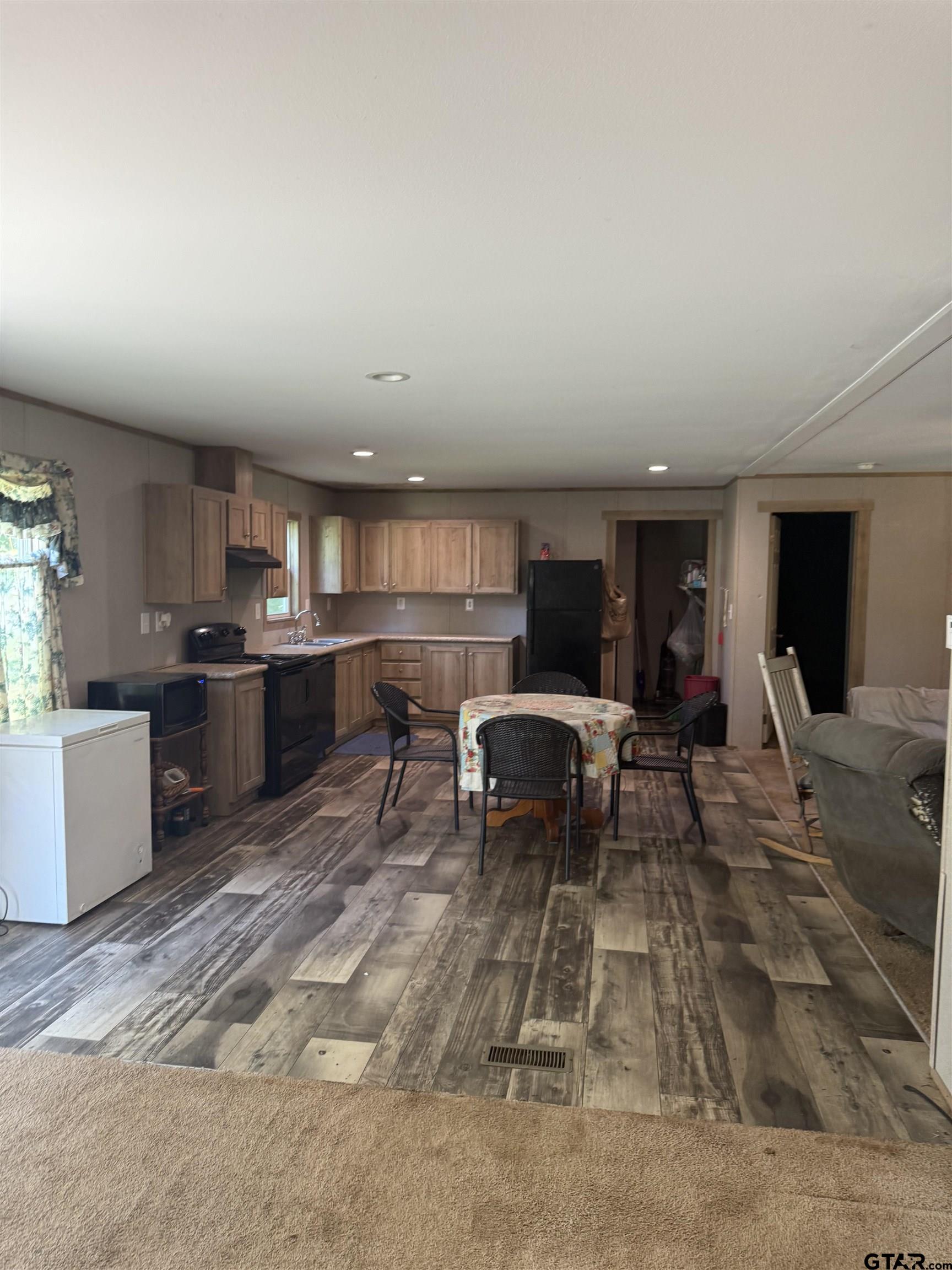 21022 County Road 240 Tyler, TX 75705 - Photo 13 of 13 a living room with furniture a table and kitchen view
