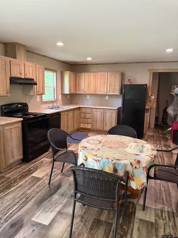 a kitchen with a dining table chairs and refrigerator