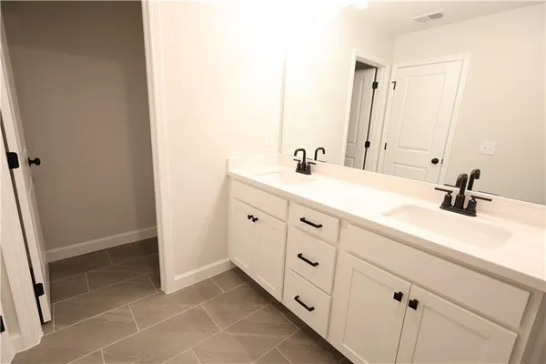 a bathroom with a double vanity sink and mirror