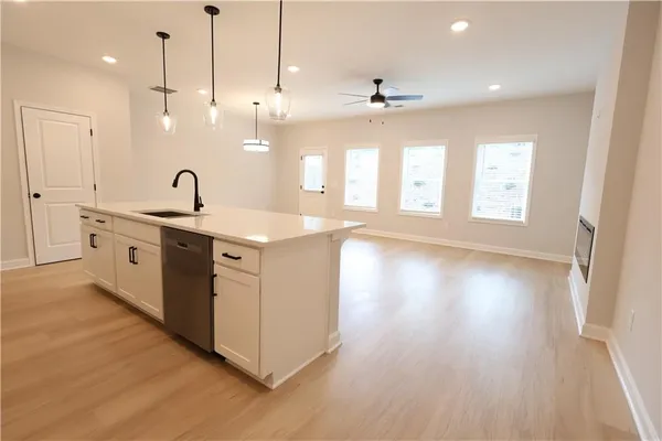 a kitchen with a sink window and wooden floor