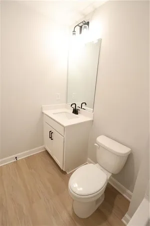 a bathroom with a toilet a sink and mirror