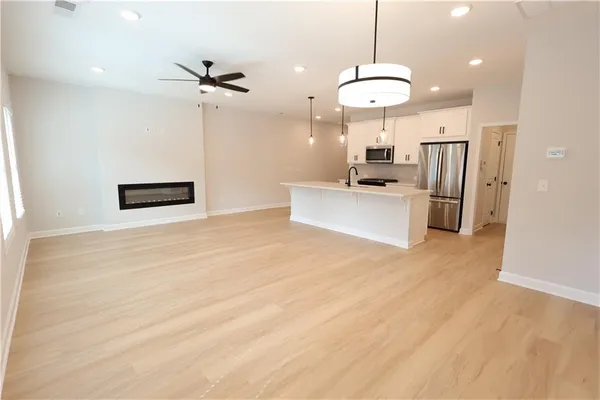 a living room with stainless steel appliances furniture a rug and a window
