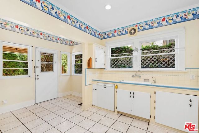 a bathroom with a sink mirror and a bathtub next to a window