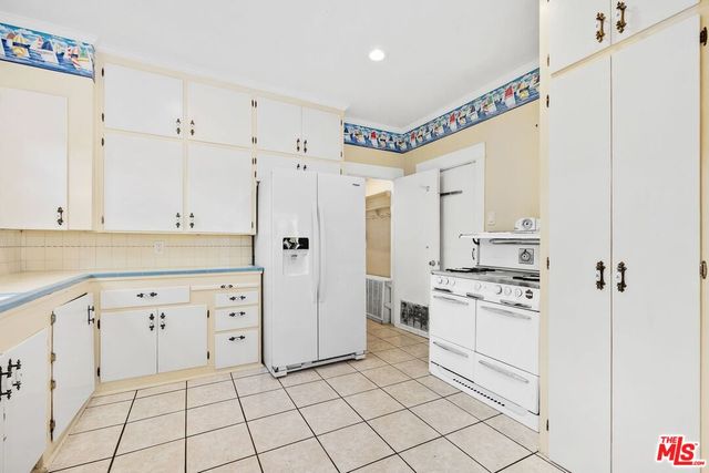 a kitchen with white cabinets and white appliances