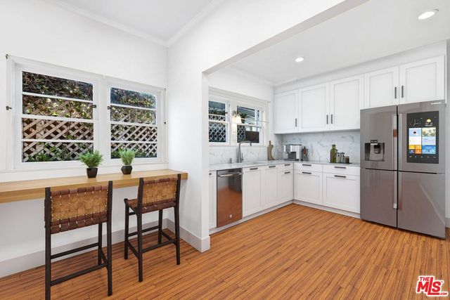 a kitchen with granite countertop wooden floors and white appliances