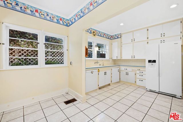 a large white kitchen with cabinets
