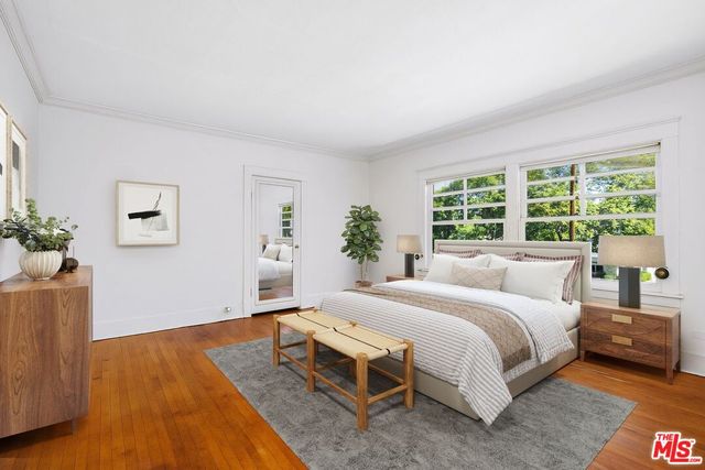 a bedroom with a large bed and a potted plant