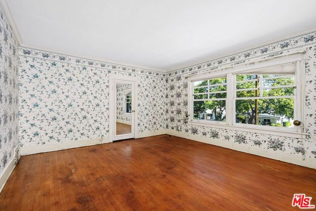 a view of wooden floor and a window in a room