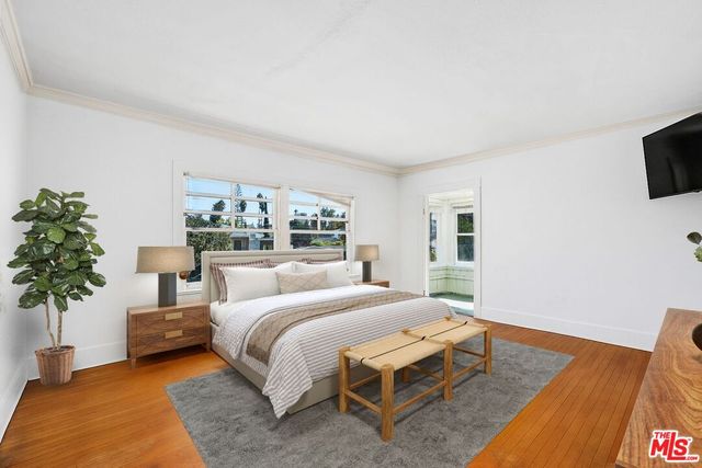 a bedroom with a large bed and a potted plant