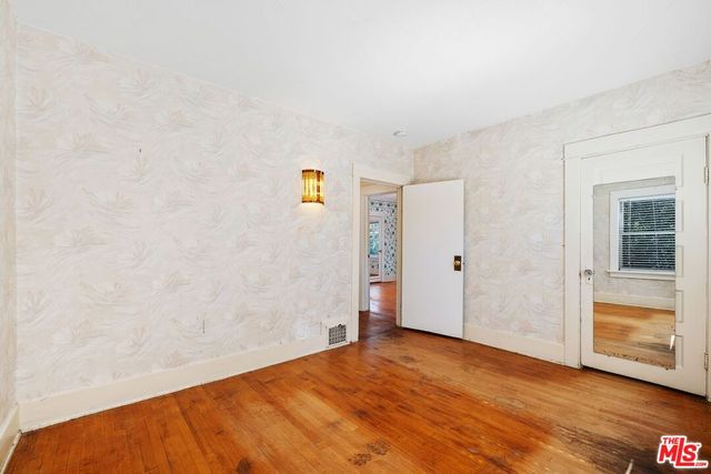 a bedroom with a bed and painting on the wall