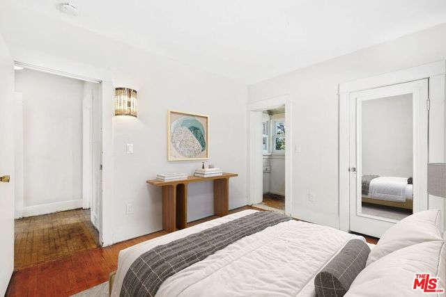 a view of an empty room with wooden floor and closet