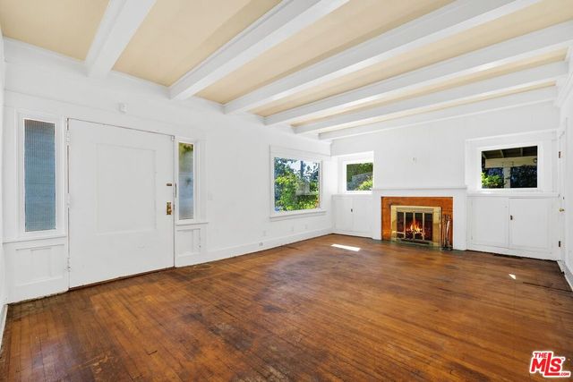a view of a livingroom with wooden floor and a fireplace