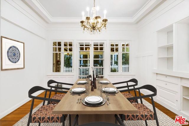 a view of a dining room with furniture a chandelier and wooden floor