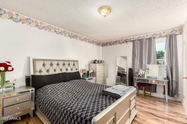 a bedroom with a bed and a table with wooden floor