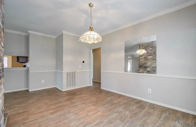 a view of a room with wooden floor and chandelier