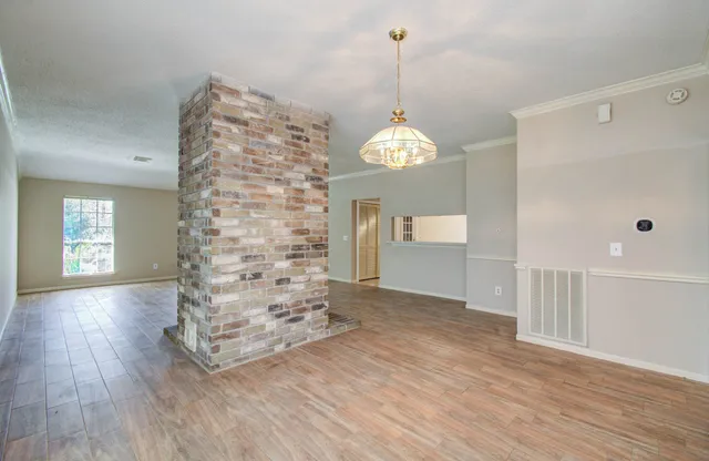 a view of empty room with wooden floor and window