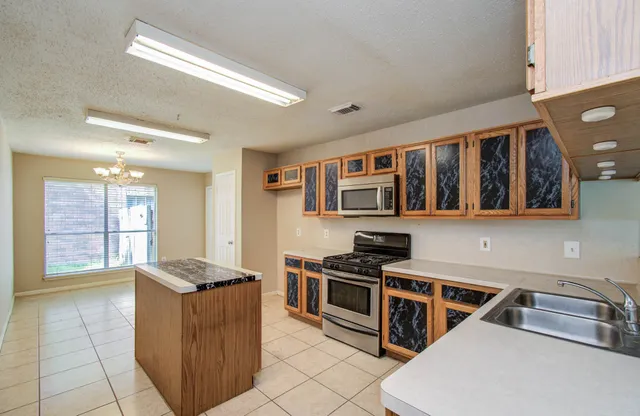 a kitchen with stainless steel appliances granite countertop a stove and a sink