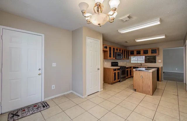 a kitchen with stainless steel appliances granite countertop a refrigerator and a stove top oven