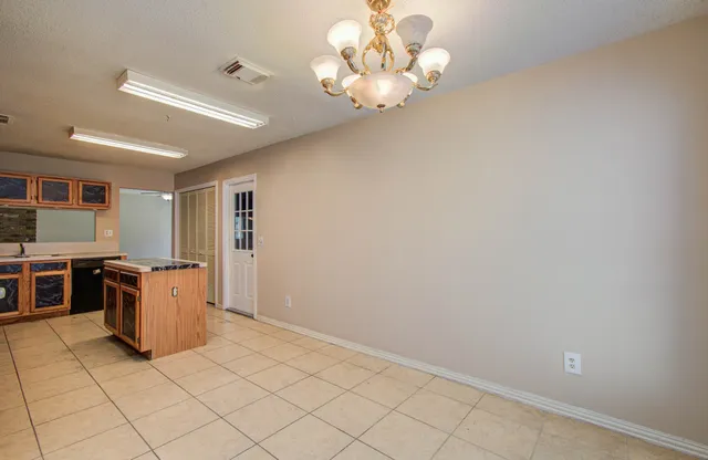 a view of a kitchen with a sink and dishwasher a refrigerator with white cabinets